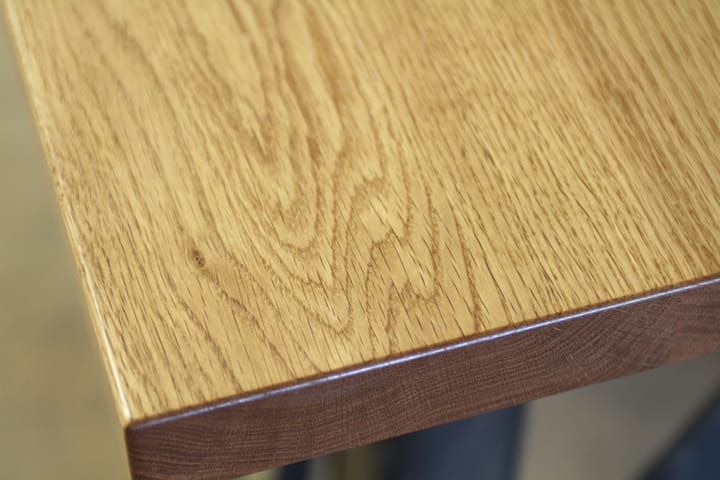 Close-up of a lacquered oak table corner showing swirling grain detail