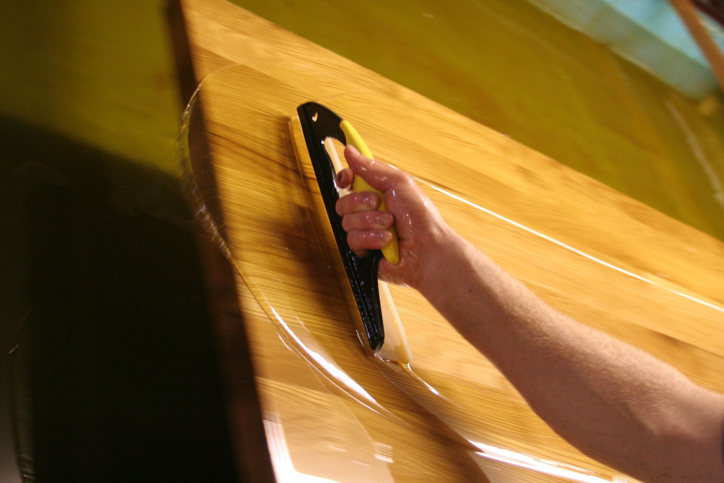 Craftsman hand-applying oil finish to an oak worktop in the workshop
