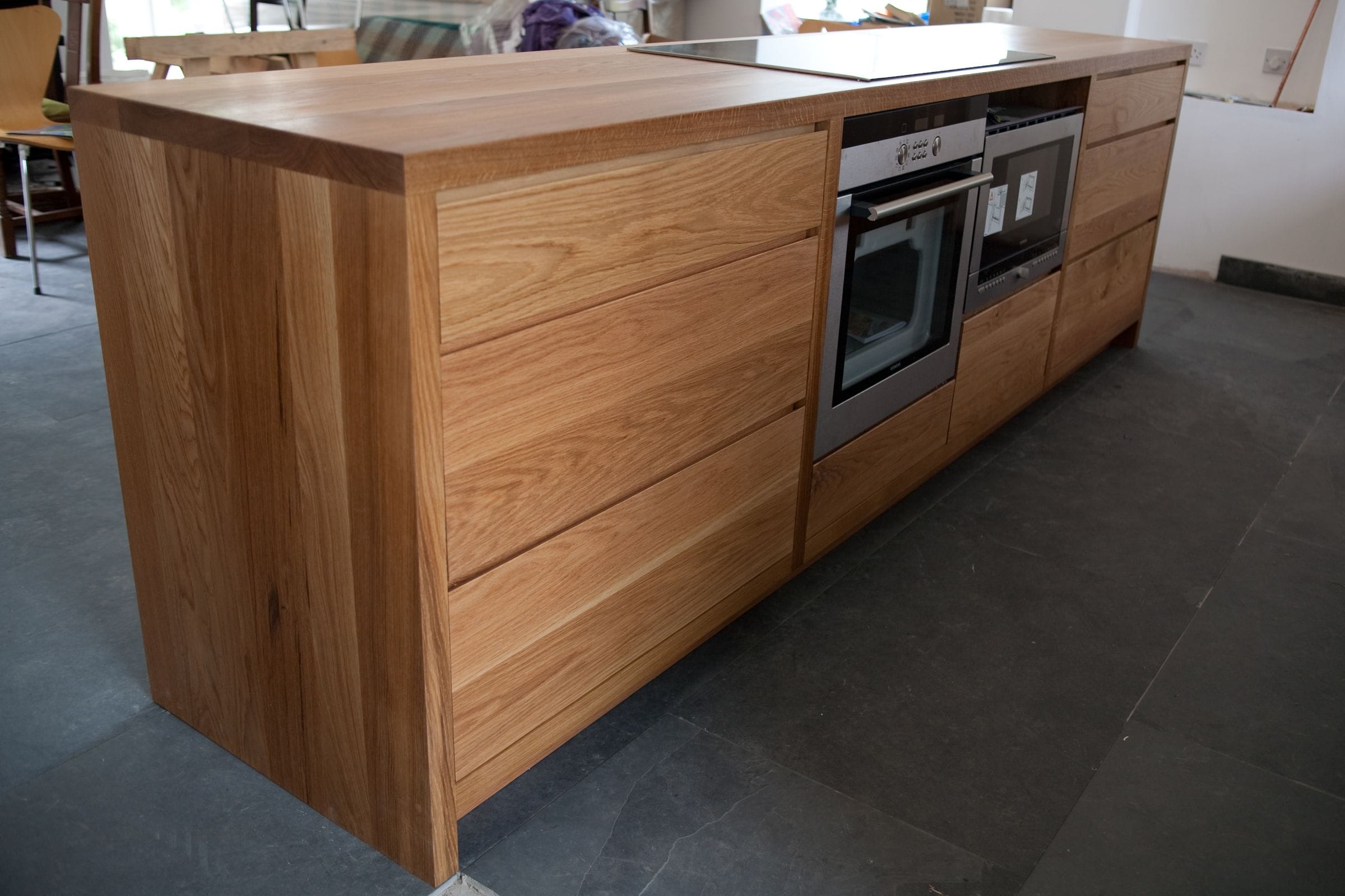 Handmade oak kitchen island with integrated double ovens and hob