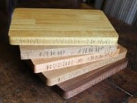 Stack of engraved wooden chopping boards in oak, iroko and walnut