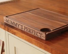 Walnut carving board engraved Mummy's Perfect resting on a walnut worktop