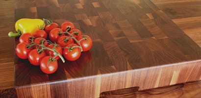 Vine tomatoes and a yellow pepper on a walnut end grain chopping block