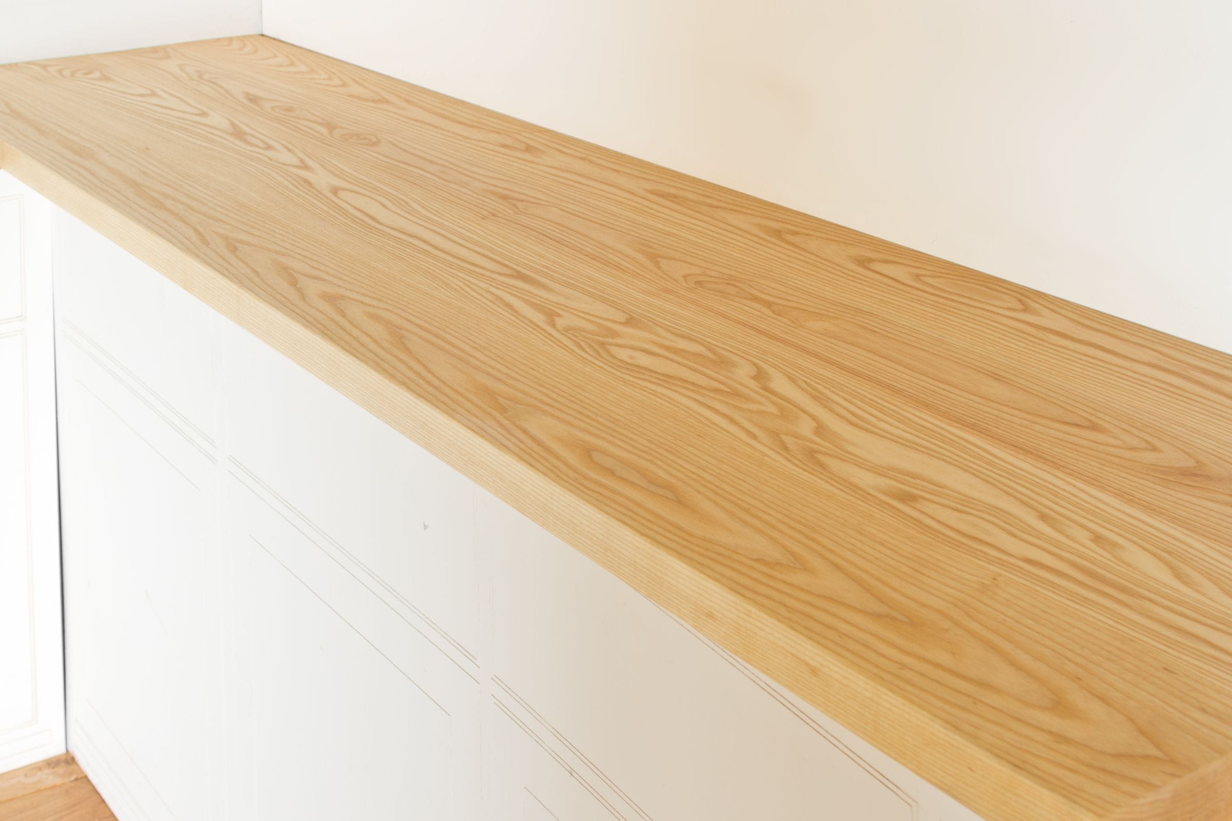 Ash super stave worktop with flowing grain fitted above white cabinetry