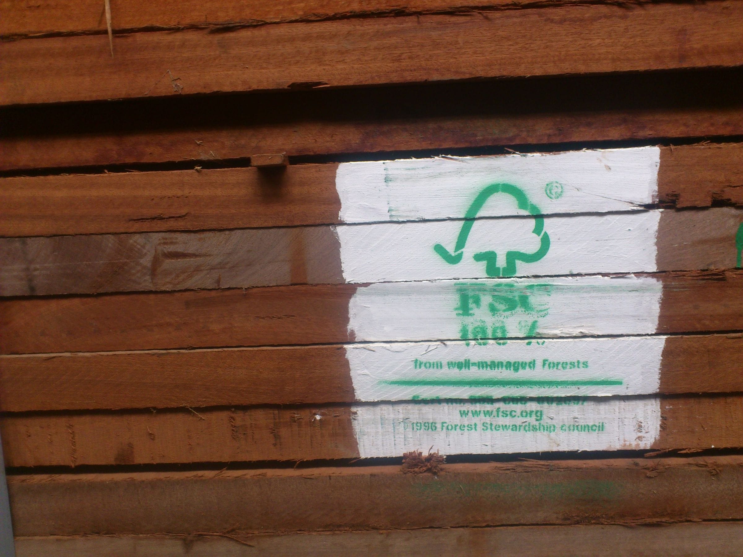 Stack of sawn mahogany boards stencilled with the FSC certification mark
