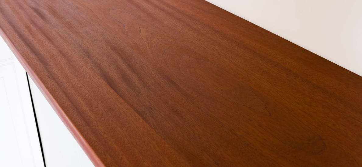 Mahogany super stave worktop with rich reddish grain above white cabinetry