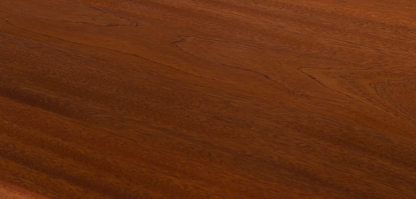 Deep reddish-brown grain of a mahogany worktop in close-up