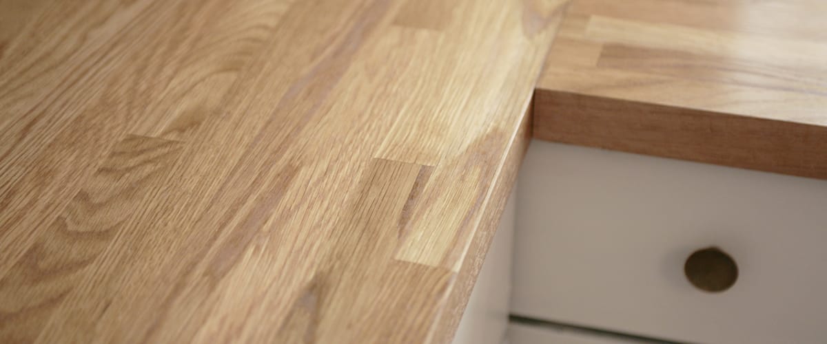 Close-up of nano-coated oak worktop grain above a white kitchen drawer