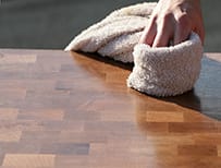 Hand applying oil to a wooden worktop with a soft cloth
