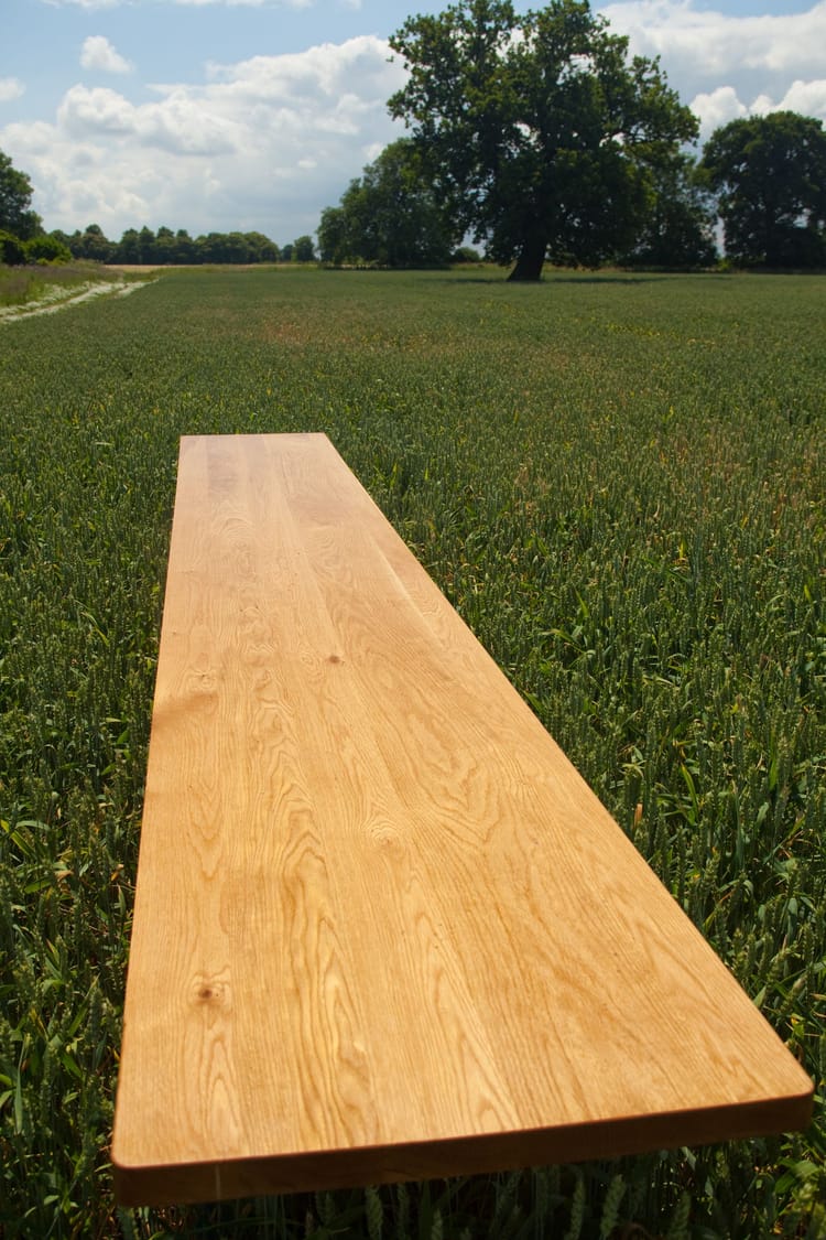 Oiled single stave oak worktop standing in a green field beneath an oak tree