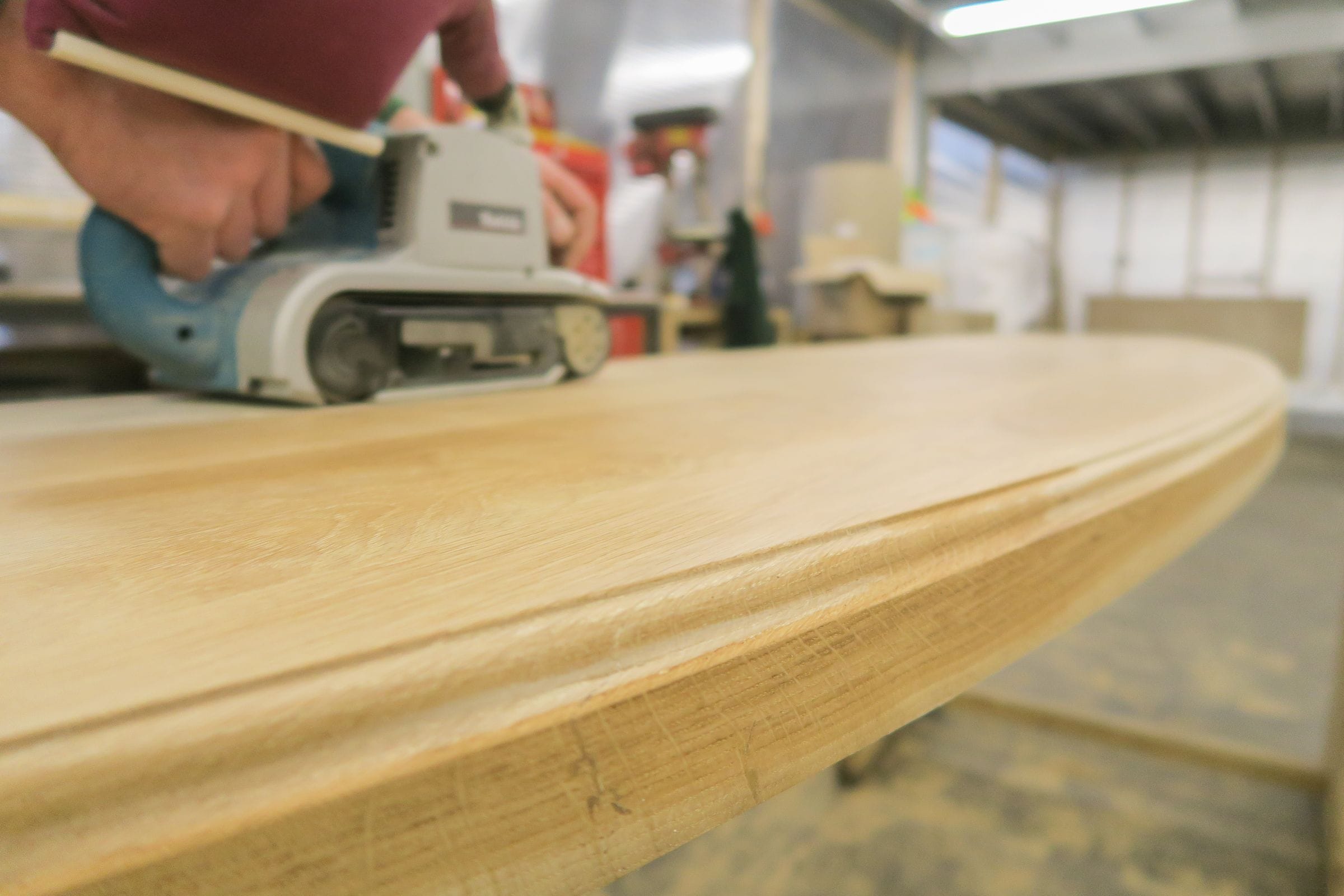 Belt sanding the edge of a curved oak worktop before finishing