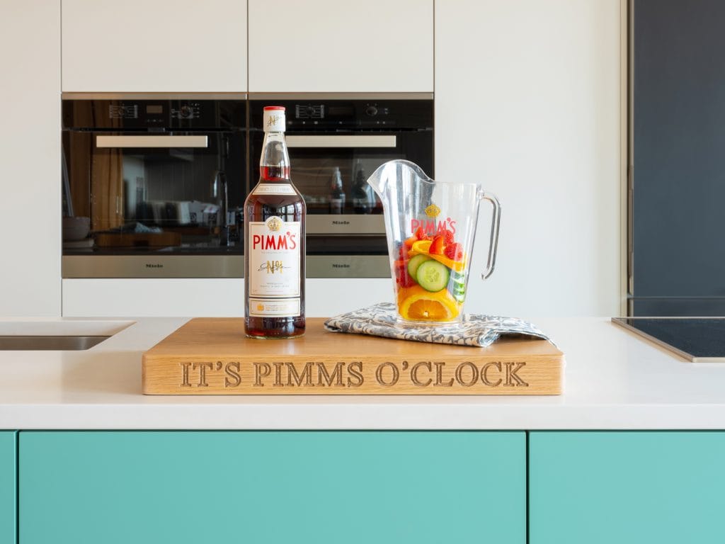 Oak board engraved 'It's Pimms O'Clock' with a bottle of Pimm's and fruit-filled jug