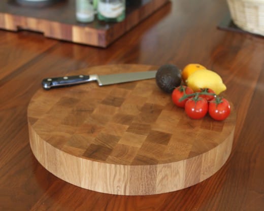 Circular oak end grain chopping block with knife and fresh tomatoes