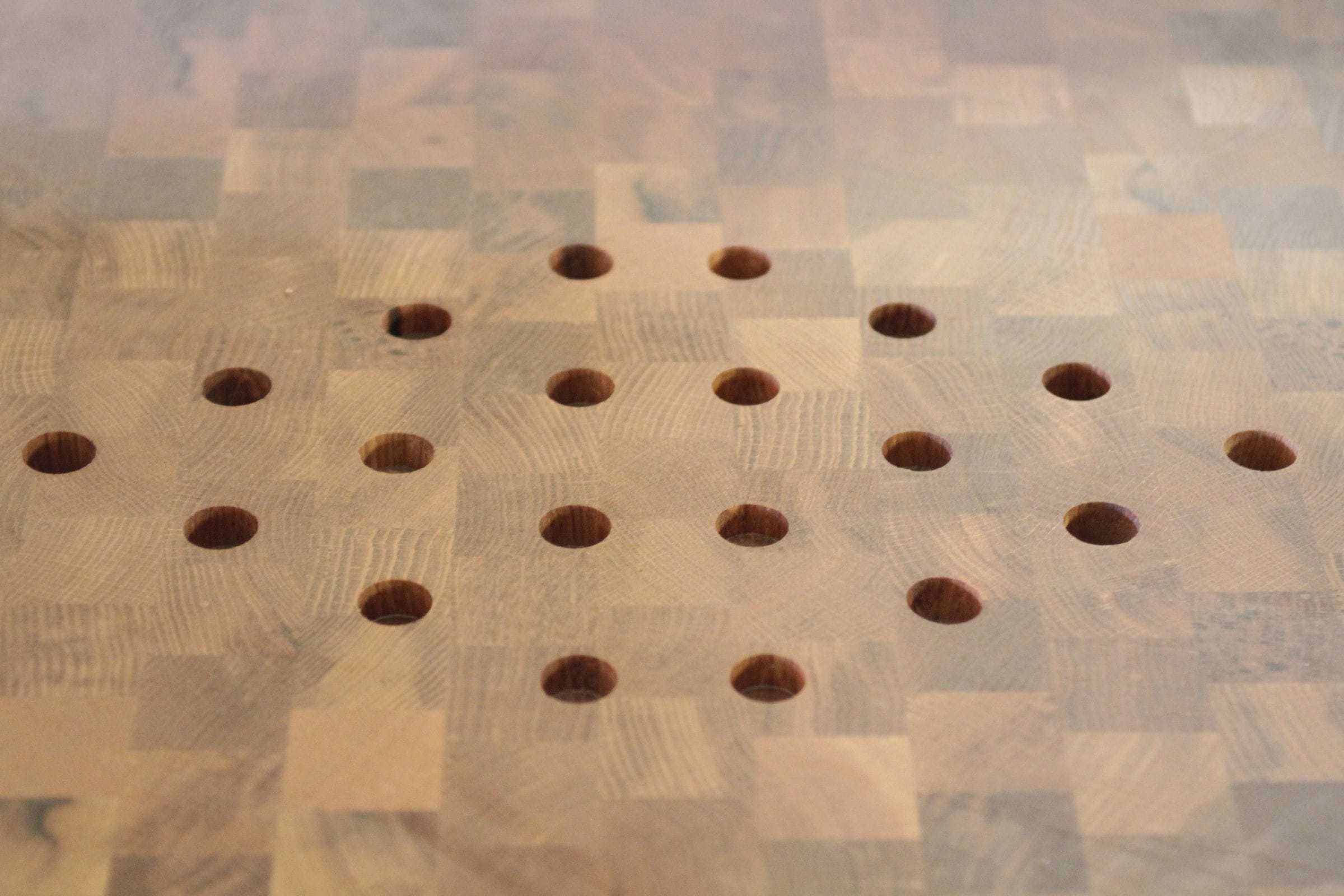 End grain chopping surface with drilled holes forming a decorative diamond pattern