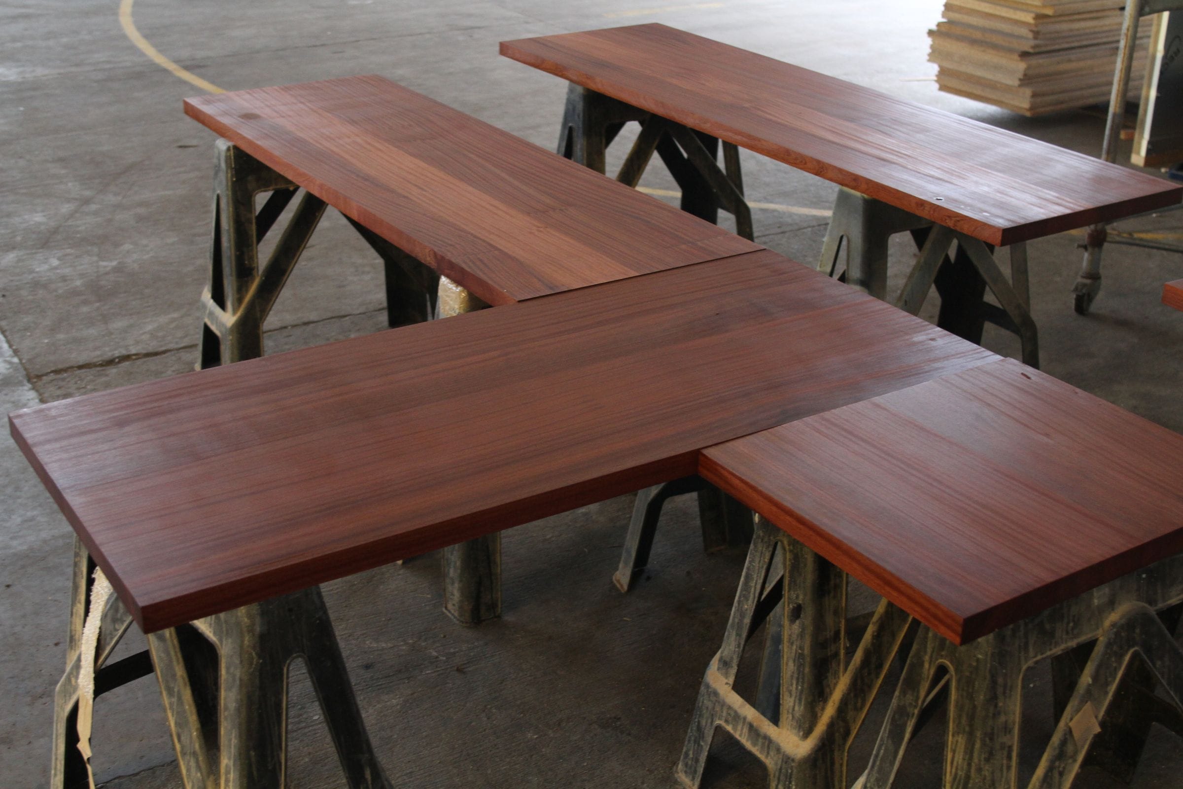 Freshly oiled sapele worktops resting on trestles in the workshop