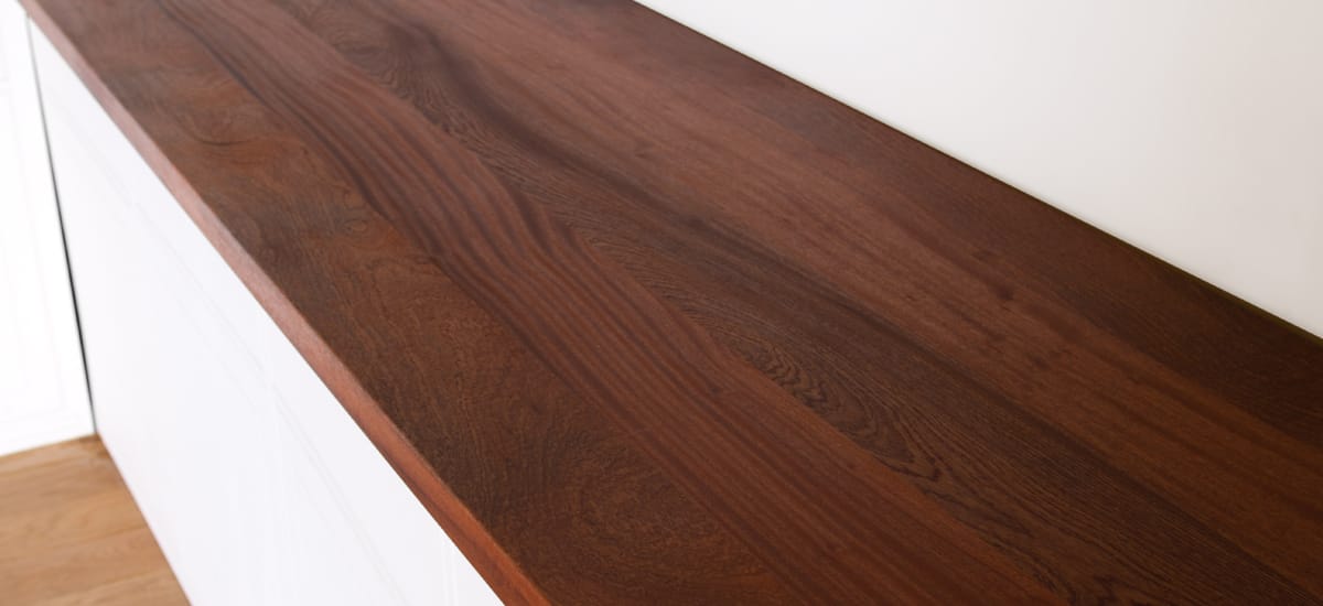 Rich reddish-brown sapele super stave worktop on white kitchen cabinets