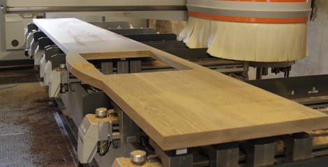 Long oak worktop with sink cutout being machined on a CNC bed