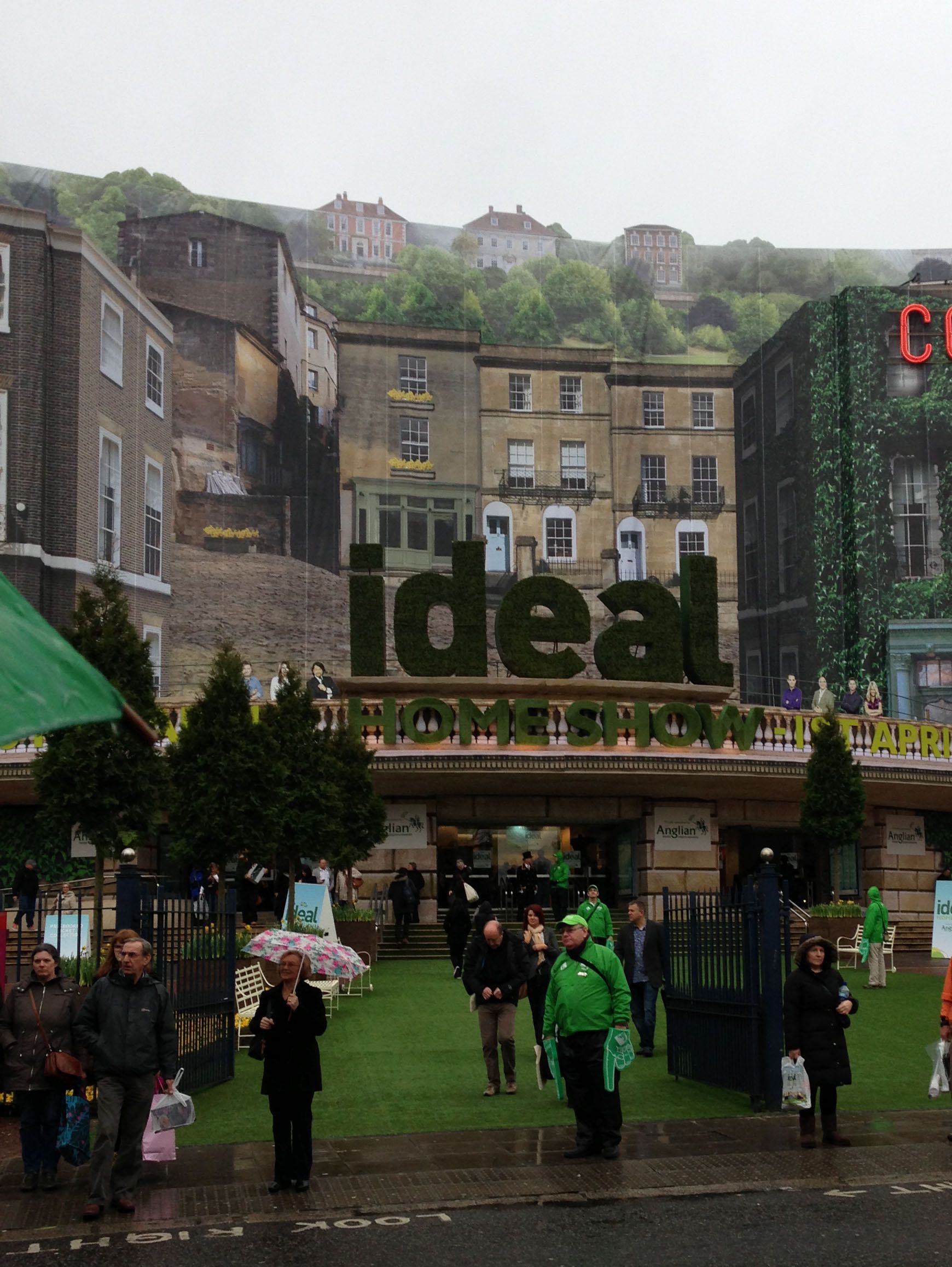 Crowds outside the Ideal Home Show entrance with topiary lettering above the doors