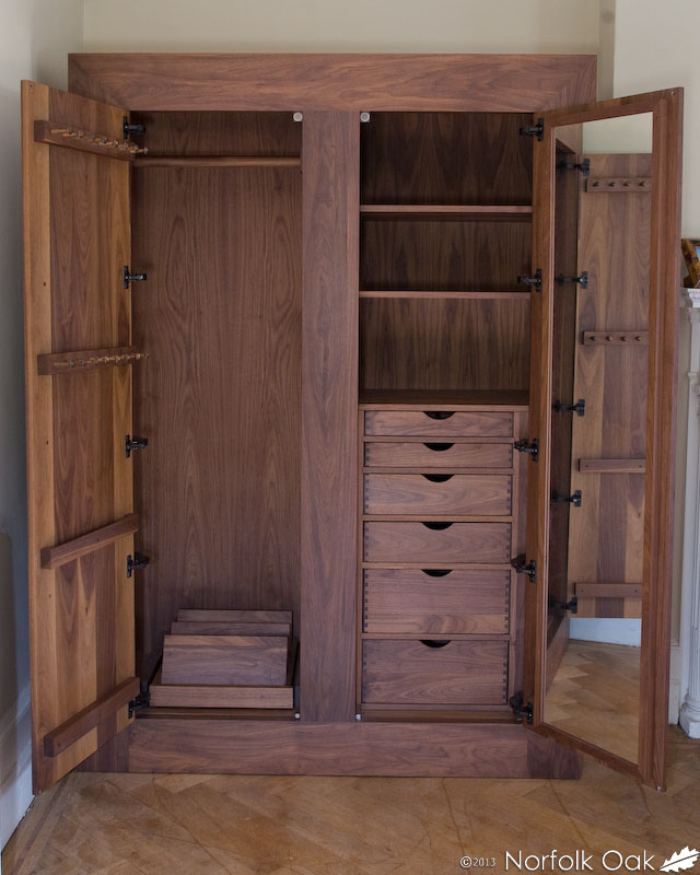 Walnut wardrobe with doors open showing shelves, drawers and mirrored interior