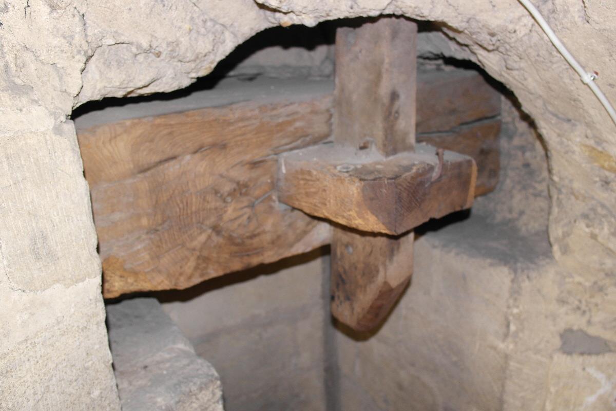 Centuries-old oak beams jointed within ancient stone masonry