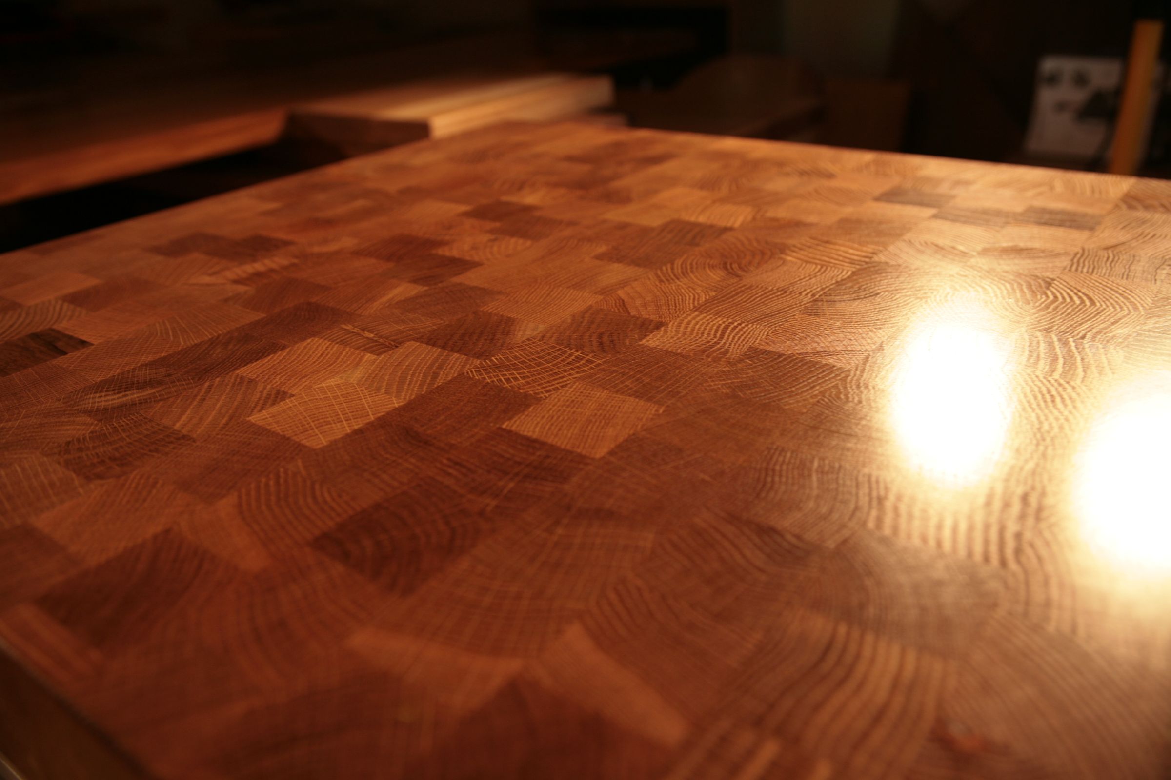 End grain oak worktop with chequerboard pattern glowing in warm light