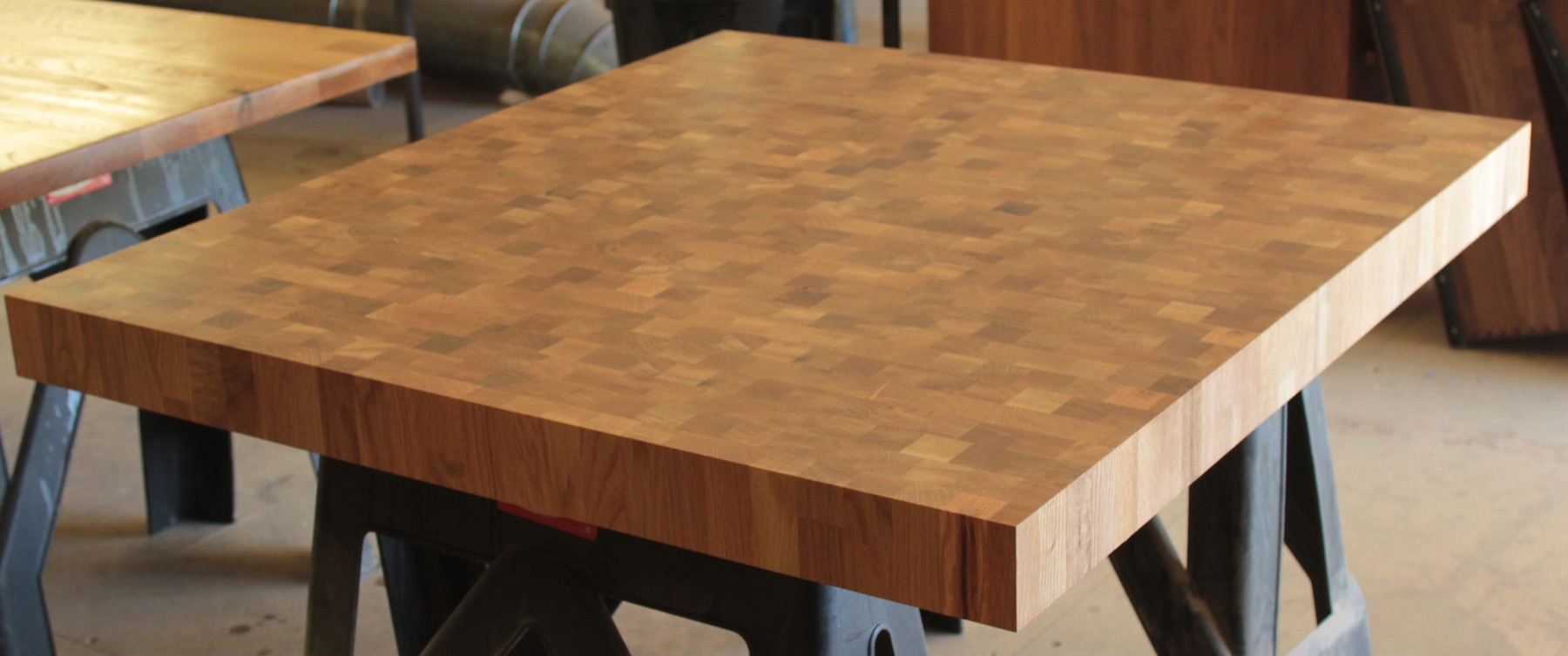 End grain oak butcher's block worktop resting on trestles in the workshop