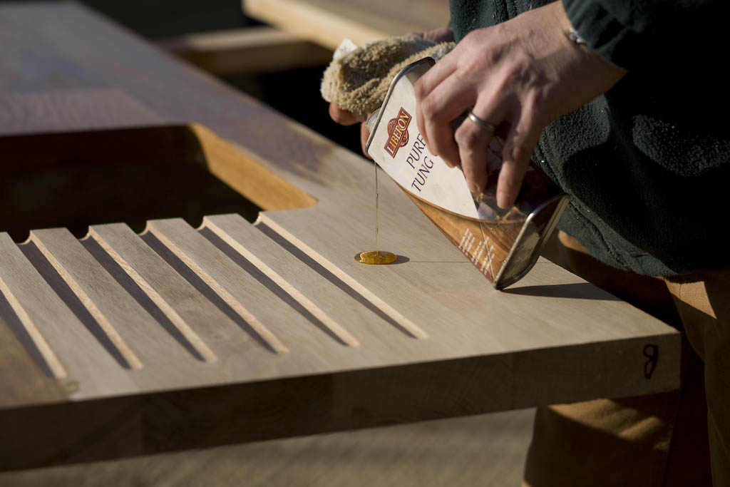 wooden worktop oiling Pouring pure tung oil onto the drainage grooves of an oak worktop