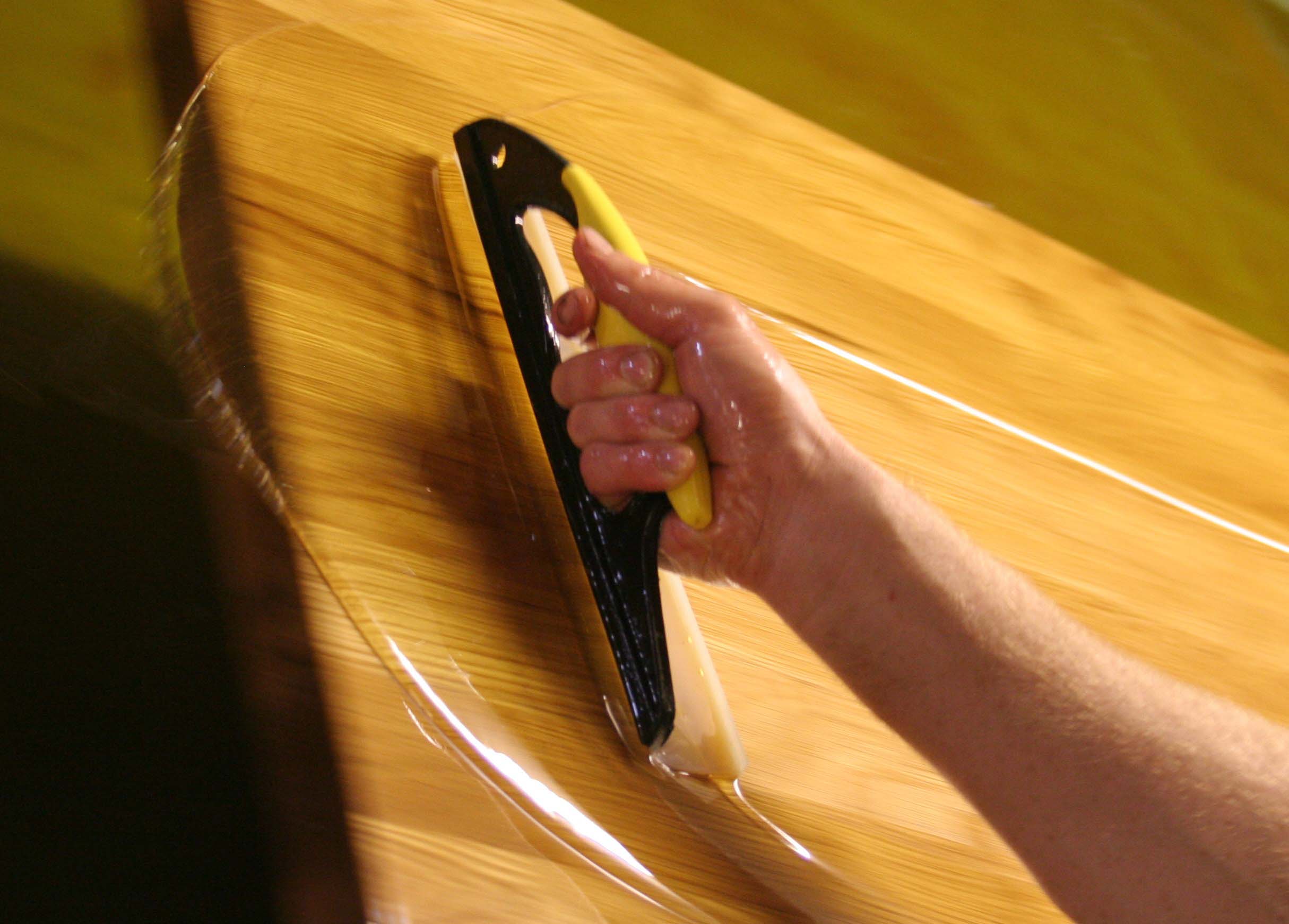 dip-tank-oiling Hand spreading oil across a freshly dipped oak worktop with a squeegee