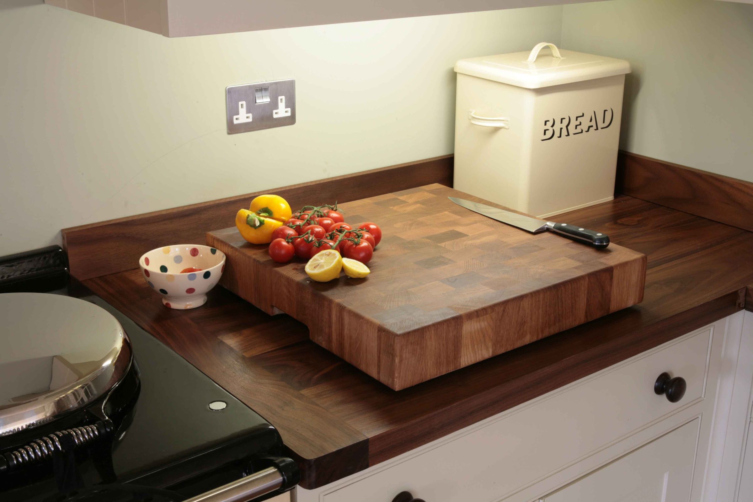 walnut chopping board Walnut end grain chopping block with tomatoes, peppers, lemon and a carving knife