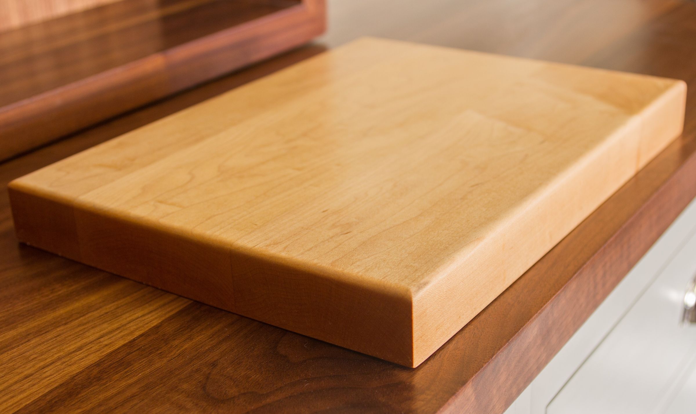 maple chopping board Thick maple chopping board with rounded edges on a walnut worktop