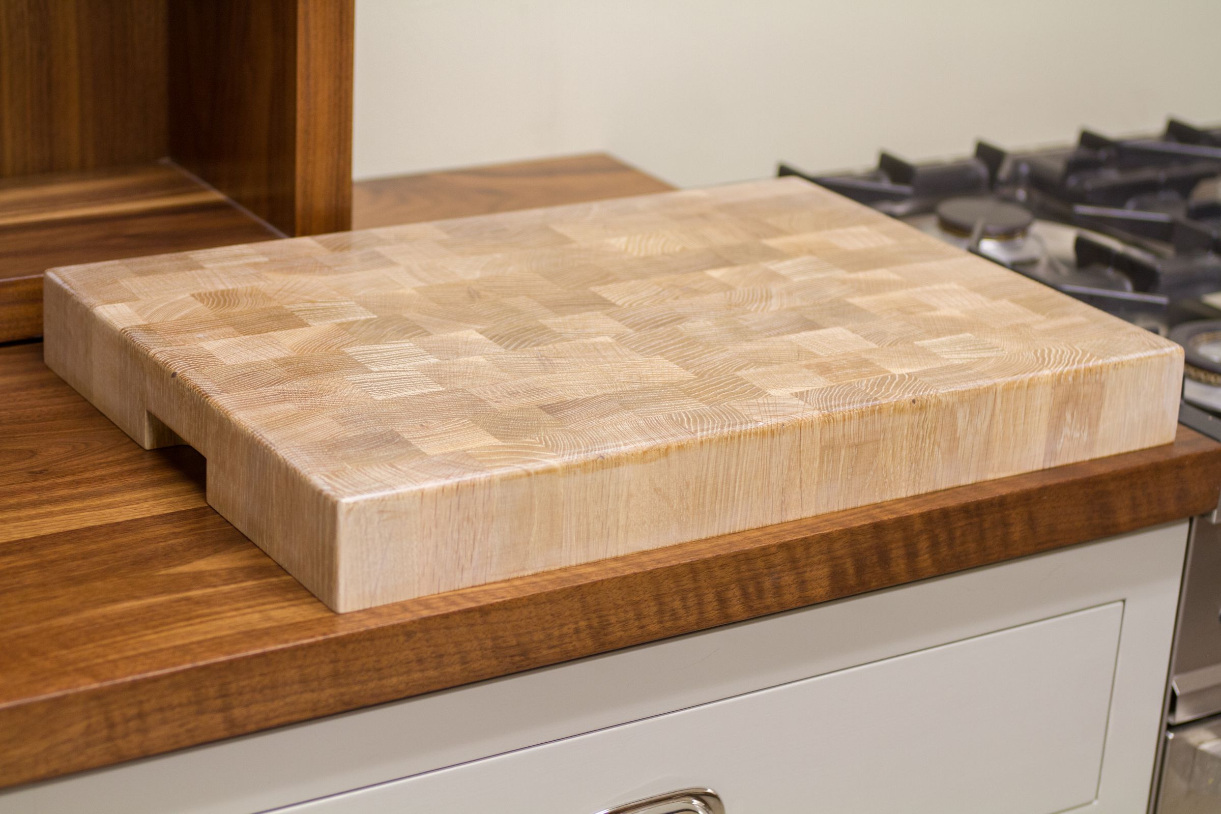 whitewash oak end grain chopping block Whitewashed oak end grain chopping block on a walnut worktop beside a gas hob