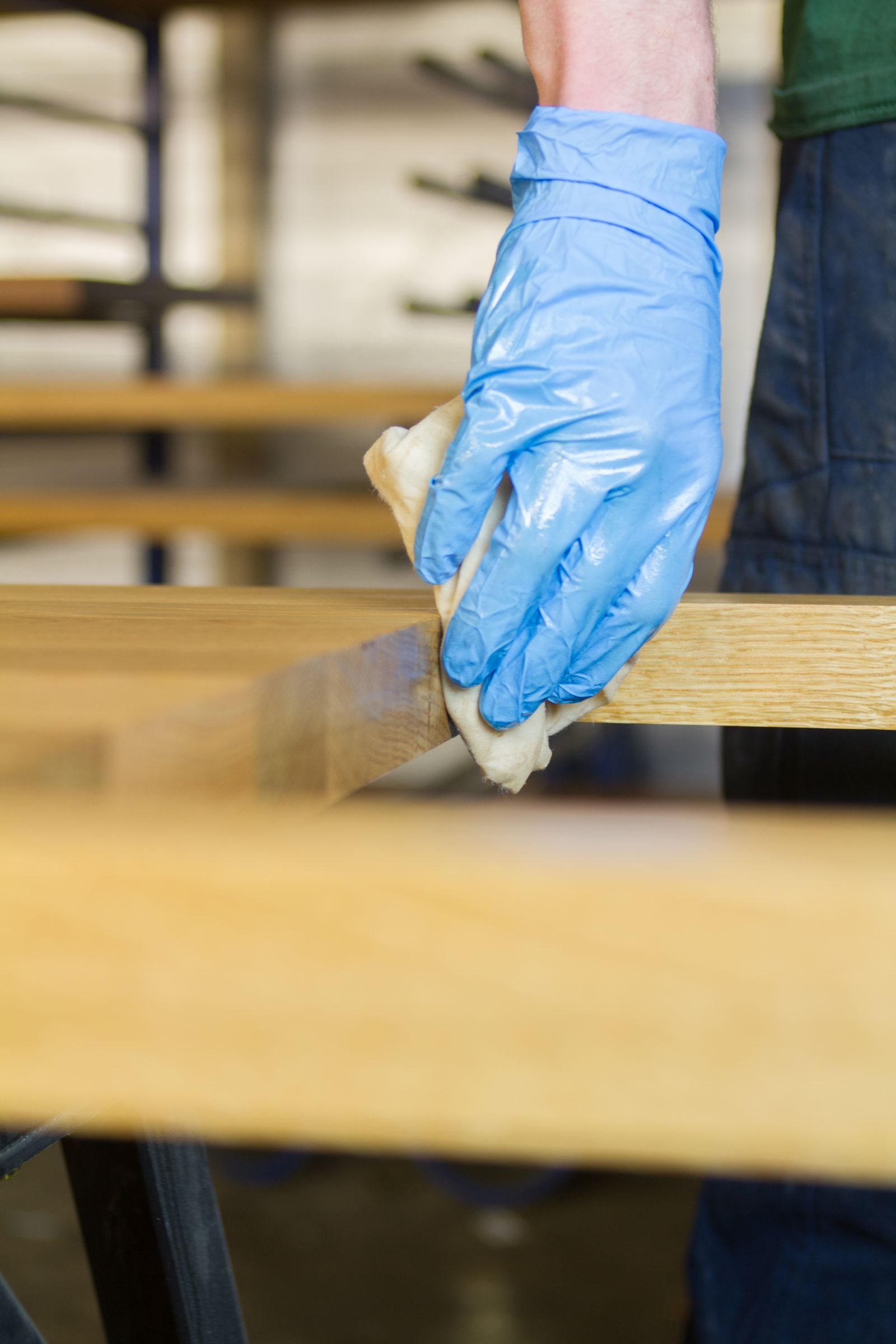oiling oak worktop Gloved hand rubbing oil into the edge of an oak worktop with a cloth