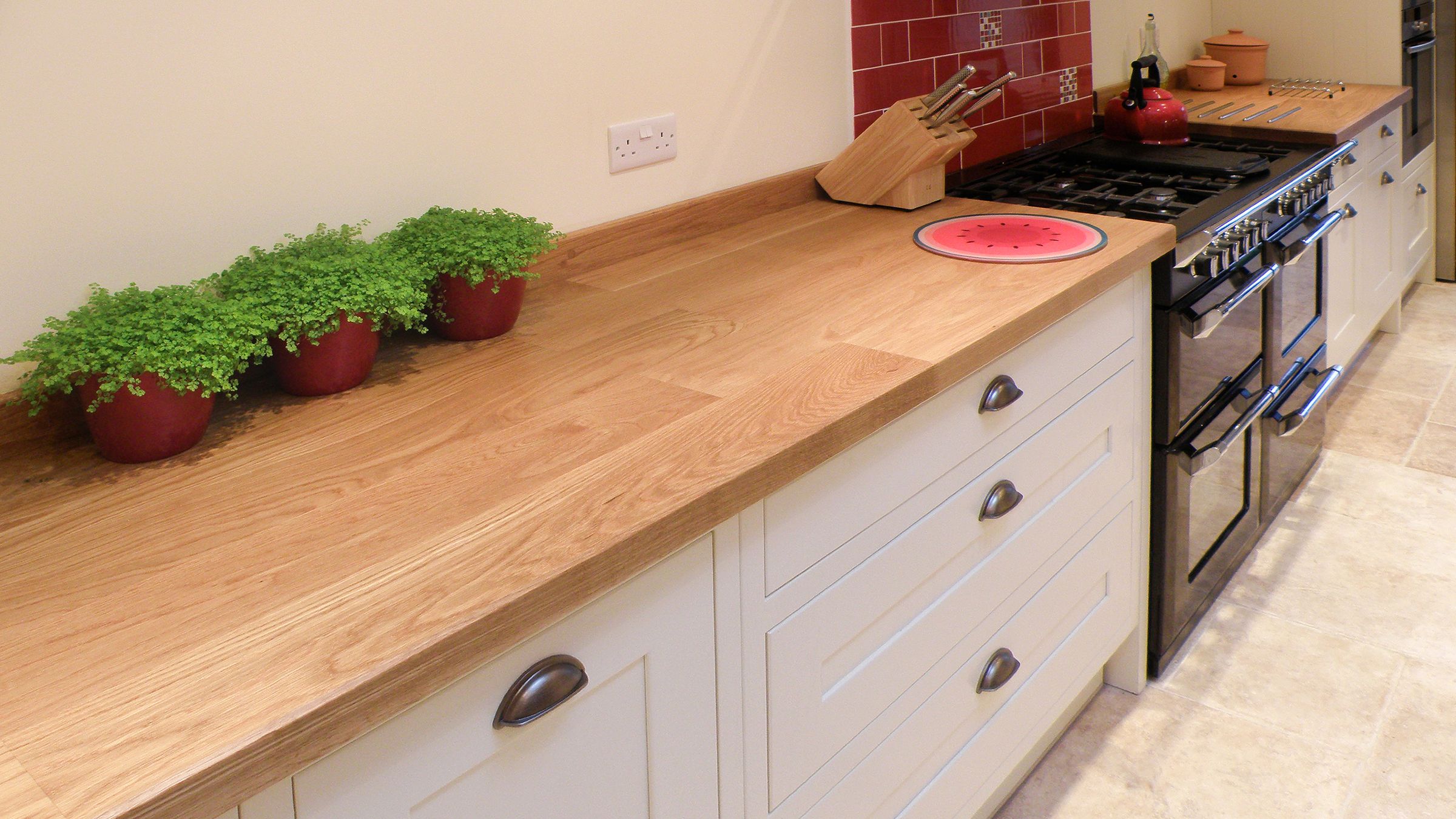 oak traditional plank worktops Traditional plank oak worktop in a cream kitchen with range cooker and potted plants