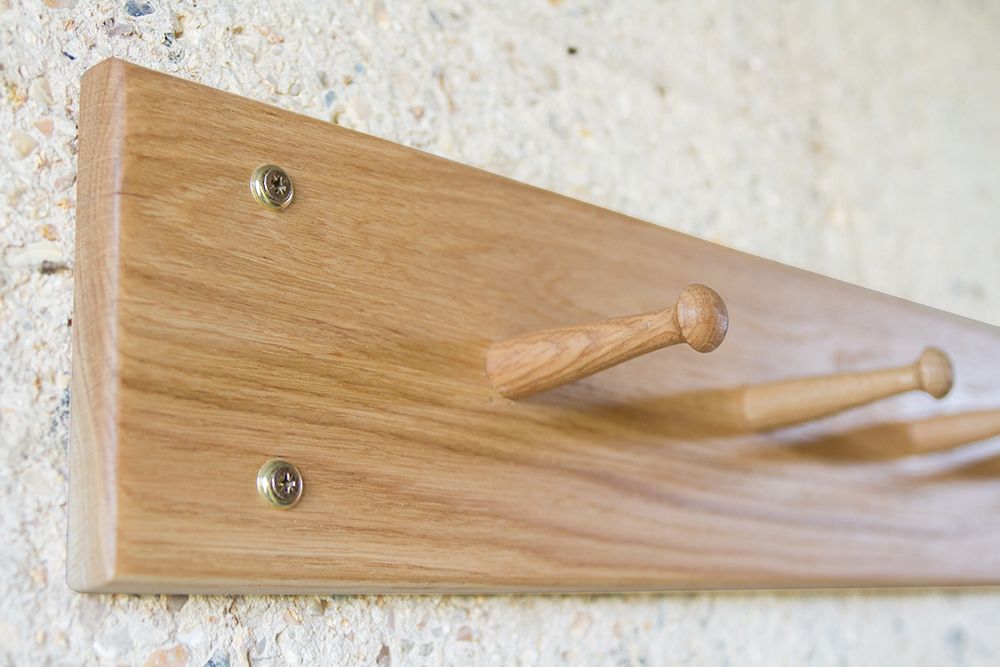 shaker oak peg rail Close-up of turned pegs on an oak Shaker peg rail against a stone wall