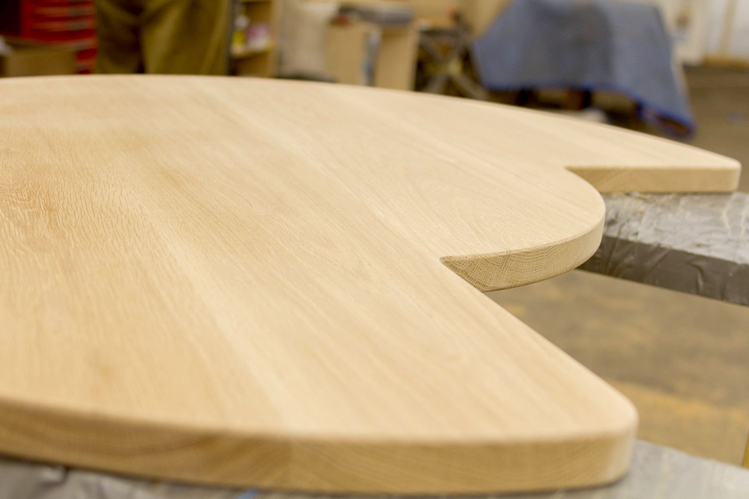 bespoke curves on oak worktop Sweeping curved edge on an unfinished bespoke oak worktop in the workshop