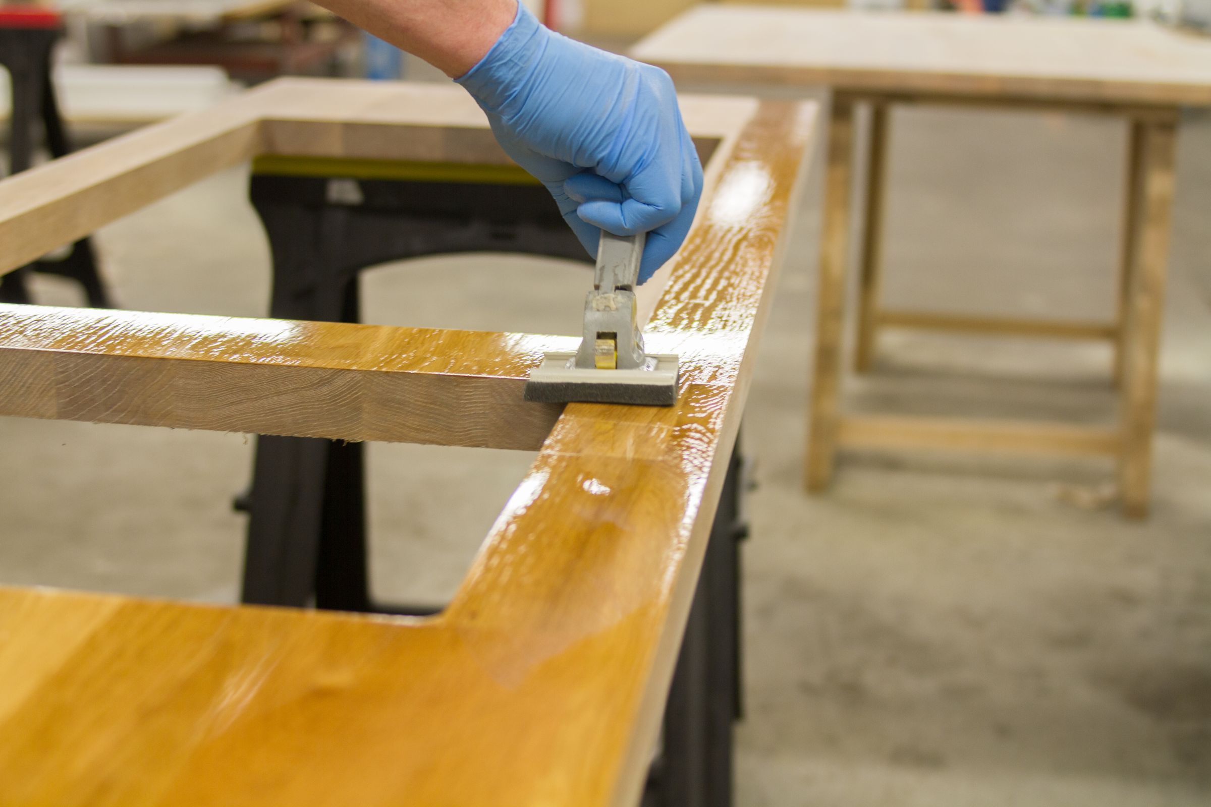 nano-coat oak worktop Gloved hand applying nano-coat oil to an oak worktop with a pad applicator