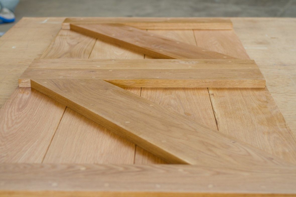 stable doors oak Solid oak stable door panels with diagonal frame bracing laid out in the workshop