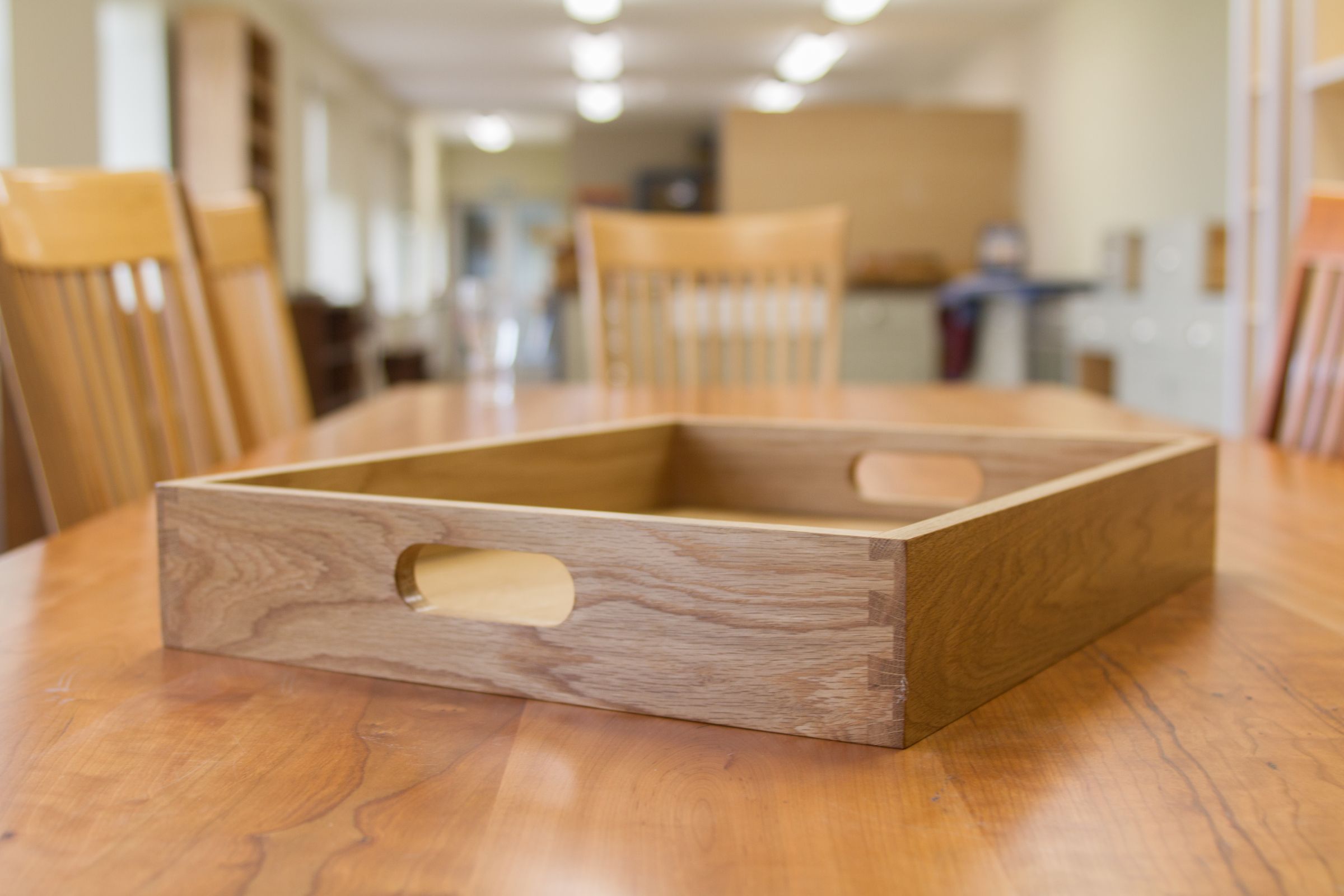 oak tray clearance Dovetailed solid oak tray with carved side handles resting on a wooden table