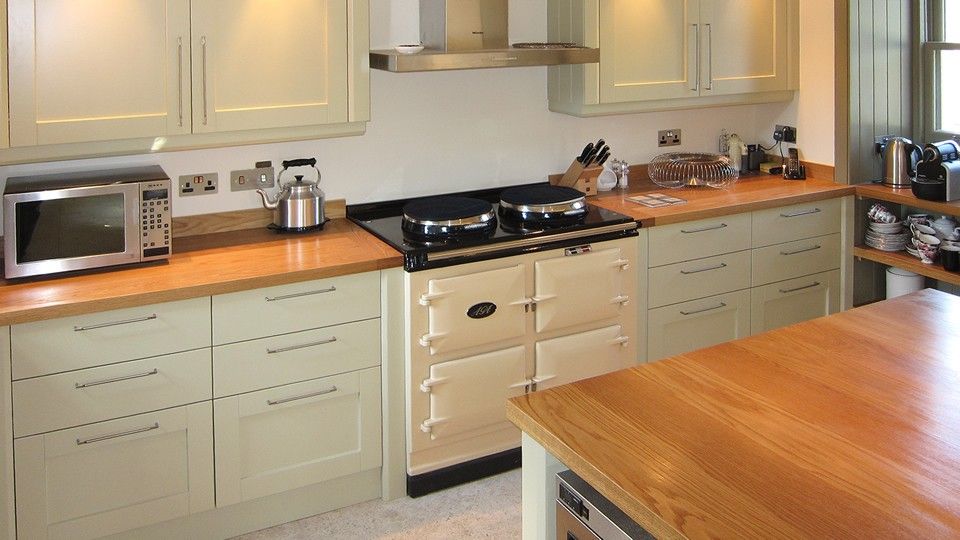 Cream country kitchen with oak worktops and a traditional Aga range cooker