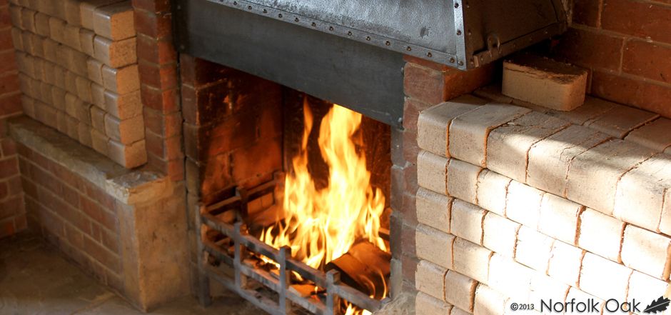 Fire blazing in a brick fireplace stacked with wooden briquettes