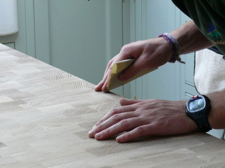 Hand-sanding an end grain worktop with a sanding block