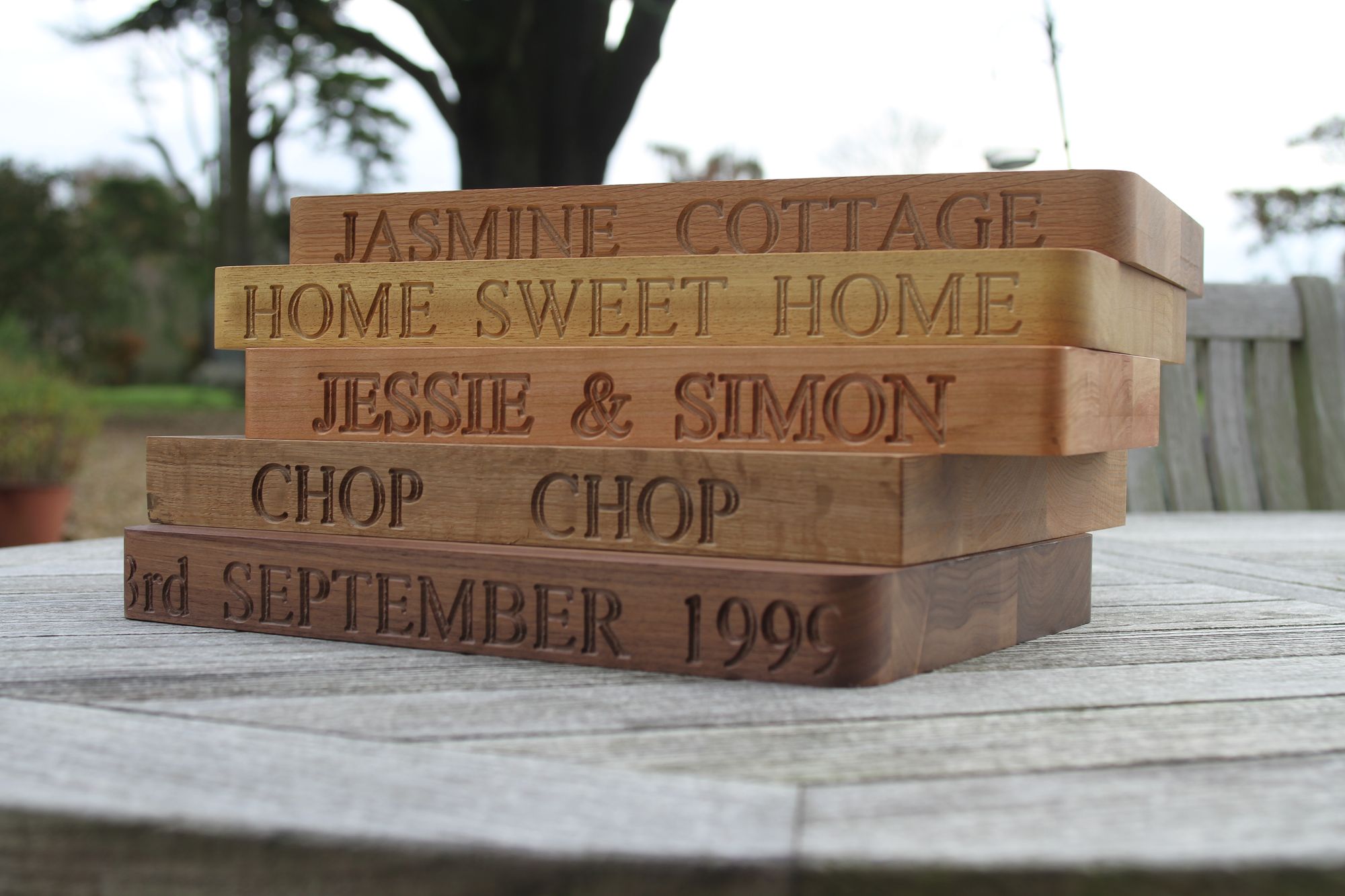 Stack of personalised engraved chopping boards with names, dates and house names