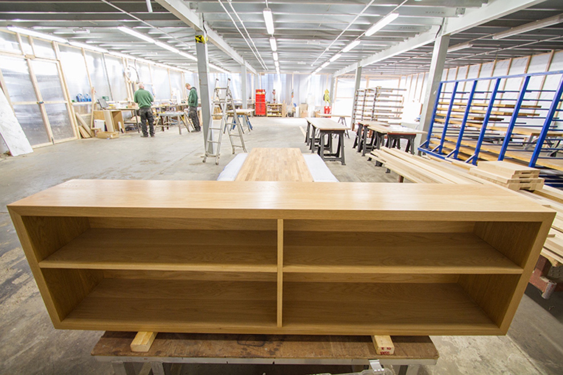 Long oak shelving unit standing on trestles in the Norfolk Oak workshop